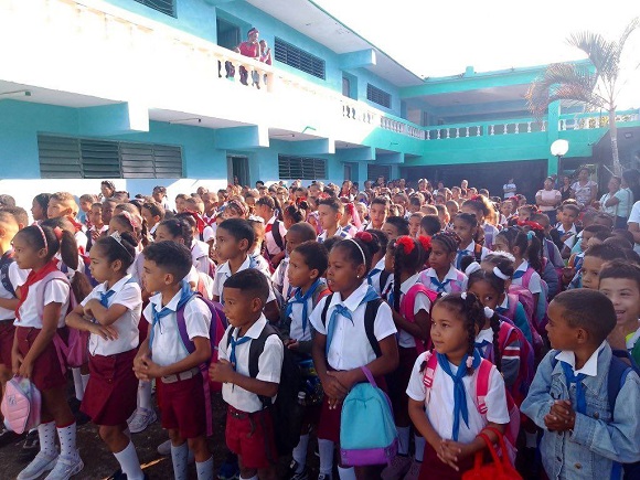 El próximo 1ro de septiembre, Cuba vivirá el inicio de un nuevo curso escolar, un esfuerzo que ha requerido de soluciones creativas y el compromiso de todos los sectores para enfrentar complejas realidades. Así lo expusieron la ministra de Educación, Dra.C. Naima Ariatne Trujillo Barreto; la viceministra primera del Ministerio de Industria, Yamilin González Milian; y el director de Comercio Mayorista del Ministerio de Comercio Interior, Ihosvany Montero García, durante la emisión de la Mesa Redonda dedicada a la preparación del período docente. La ministra de Educación, Dra.C. Naima Ariatne Trujillo Barreto, destacó el compromiso y la capacidad de cada territorio para encontrar variantes propias y priorizar sus recursos. “Cada proyecto educativo se tiene que parecer a su territorio, a las condiciones”, afirmó, subrayando la flexibilidad del sistema. Un ejemplo emblemático es Santiago de Cuba, un territorio que, según Trujillo Barreto, “tiene hoy un 99% de su cobertura docente” y ha encontrado “muchísimas variantes, incluso para poder tener algunas iniciativas para aseguramientos tecnológicos”. Reconoció que la situación no es homogénea en el país, pero resaltó la unidad: “Nos encontramos trabajadores de todos los sectores así unidos. Eso creo que es algo que pudimos apreciar en todas partes”. La búsqueda de respuestas a nivel municipal y comunitario ha sido una característica singular de este año. La ministra explicó que el perfeccionamiento del sistema educativo y las propias necesidades han impulsado alianzas. “Hemos aprendido también en el trabajo en redes y las soluciones en los municipios. Y entonces hay una respuesta más estable”, aseguró. Esto se ha traducido en vínculos inéditos para el mantenimiento de las escuelas. “Hoy lo mismo nos podemos encontrar en la escuela rural, donde una cooperativa está aportando, que la labor de familias que se unen o empresas de determinada área de producción con una respuesta”. Un testimonio conmovedor de esta resiliencia es la provincia de Guantánamo, severamente afectada por eventos climatológicos. “Guantánamo va a estar recuperando la última institución educativa pendiente, el propio 1ro de septiembre, en una comunidad rural donde no quedó nada de la escuela”, anunció la ministra, destacando el trabajo intenso de su gente. Más de 1 500 000 estudiantes cubanos, desde el preescolar hasta el preuniversitario, incluidas las escuelas especiales y de formación profesional, iniciarán el curso escolar el 1 de septiembre. El papel de la industria Por su parte, Yamilin González Milian, del Ministerio de Industrias, detalló los desafíos para asegurar productos esenciales como libretas y, sobre todo, los uniformes escolares. Ante una demanda total de más de 3.6 millones de prendas, la industria solo pudo financiar y producir 2.2 millones. El mayor reto, explicó, ha sido la contingencia energética: “La disponibilidad de combustible para el traslado y la recuperación de todas las prendas una vez producidas”. La solución, una vez más, ha venido de la coordinación y el apoyo mutuo. “Hemos trabajado muy coordinados con los gobiernos territoriales”, dijo. Relató cómo se utilizaron grupos electrógenos en fábricas de Villa Clara, Santiago de Cuba y otros territorios para mantener la producción durante los apagones, e incluso cómo provincias como Guantánamo y Santiago, al terminar sus compromisos, apoyaron a Gramma, una de las más afectadas por la falta de electricidad. La prioridad fue cubrir los grados iniciales (preescolar, 5° y 7°), cuyos uniformes ya están en el comercio. La producción continuará en septiembre y octubre para completar alrededor de 800 000 prendas más para el primer año y otros grados. La viceministra rindió homenaje a los colectivos mayoritariamente femeninos de la industria: “Son mujeres que tienen que atender a nuestras familias y han hecho un esfuerzo enorme, con un tremendo compromiso”. En ese sentido, la ministra de Educación señaló que en este proceso convergen los tiempos de la industria, del comercio y la familia. El más importante es el de la familia, que es a quien se debe tributar. El acto de preparación de las aulas también refleja esta diversidad de soluciones. Sobre las imágenes de aulas con libros dispuestos en los pupitres, la ministra aclaró que “las escuelas de conjunto con su familia tienen diversas variantes”. En algunos casos las familias acuden estos días a la escuela, otras recuperan libros usados, y “ha habido una tradición en los últimos años de que muchas aulas y profesores prefieren recibir así con ese orden”. La Dra.C. Naima Trujillo envió un mensaje de reconocimiento: “No habrá ningún territorio de Cuba que no haya hecho el mayor esfuerzo. Estamos muy motivados, nos anima mucho, nos impulsa además a hacer mejor las cosas”. El comercio interior en este proceso Foto: Tomada del sitio oficial de Ministerio del Comercio Interior. En otro momento de la Mesa Redonda, Ihosvany Montero García, director de Comercio Mayorista del Ministerio de Comercio Interior, señaló que su organismo mantiene un aseguramiento para el inicio del nuevo curso que busca conciliar la producción y comercialización, en un escenario donde la distribución del uniforme escolar es tarea de primer orden. “Desde el pasado 15 de julio comenzó en Cuba la comercialización del uniforme, dando prioridad a los grados iniciales de primaria y secundaria. Actualmente tenemos vendido más del 80% de estas piezas, equivalente a unas 500 000 prendas”, dijo Montero García. Explicó que, si bien se espera entregar a los estudiantes dos uniformes, hasta el momento se comercializa solo uno y el otro se distribuirá más adelante. Comentó que existe un sistema que permite recibir información sobre las ventas desde todo el territorio nacional, y el inicio de la comercialización en julio permitió disminuir la aglomeración de personas en los puntos de venta. “Para una segunda etapa estamos evaluando la venta de uniformes a los estudiantes de enseñanza pedagógica, primer año de preuniversitario y enseñanza técnico profesional”. Según Montero García, algunos territorios del país ya comercializan tallas más grandes destinadas a estos estudiantes. Ultimando detalles Pioneros de la escuela primaria Guerrillero Heroico. Foto: Enrique González (Enro)/ Cubadebate. Una escuela pedagógica de Pinar del Río, fundada por Fidel el 1ro de septiembre de 1975, será escenario de el acto central por el inicio del curso escolar en el país. No obstante, cada provincia tendrá su propia celebración, tanto en plazas abiertas, como en instituciones relevantes de la comunidad, pues, en palabras de la ministra de Educación, “el hecho educativo es un hecho social transversal a toda la familia”. Entre las novedades del período lectivo que se avecina, Naima Ariatne Trujillo Barreto mencionó el tercer perfeccionamiento, proceso a partir del cual se introdujo una transformación del tercer grupo de grados (tercero, sexto, noveno y duodécimo). “Los materiales y textos han llegado de forma paulatina y, entre septiembre y octubre, arribarán al país los del tercer grupo, que se han obtenido con mucho esfuerzo”, señaló. Comentó que una de las prioridades del tercer perfeccionamiento es desarrollar un curso donde la comunicación sea prioritaria. “Pretendemos continuar fortaleciendo el trabajo educativo integral con materiales curriculares, pero sobre todo con formación integral, que ventile temas vinculados con la droga, el embarazo en la adolescencia, entre otros preocupantes en la sociedad”, comentó. También mencionó a la importancia de preparar a los integrantes del sistema educativo ante la inminente publicación del nuevo Código de la Niñez, las Adolescencias y las Juventudes. En ese camino, el próximo curso escolar en Cuba se presentará como un testimonio de la capacidad del pueblo para buscar soluciones, incluso en medio de la adversidad.