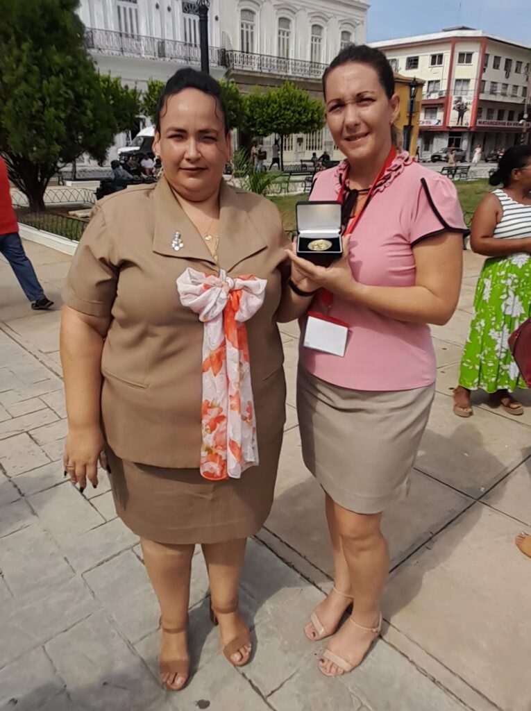 Yeneris junto a Yanetsy Chávez Camaraza, Directora Provincial del Banco de Crédito y Comercio Bandec, recibiendo la Medalla 85 Aniversario de la CTC.